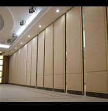 Cream movable partition panels closed down one side of a banqueting room with a moulded ceiling.