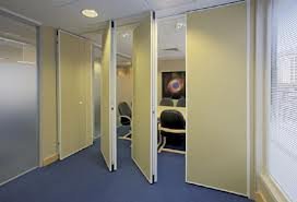 Cream movable partition panels with one panel swung open onto a meeting room beyond.